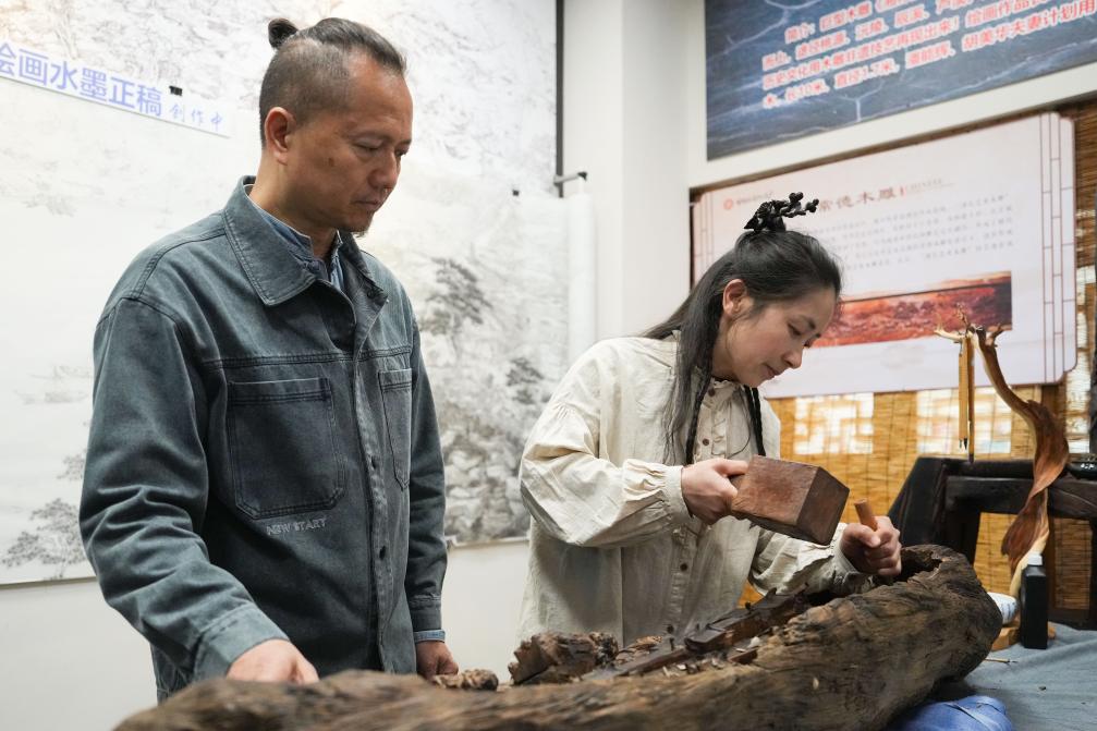 Pan Nenghui and his wife Hu Meihua show wood carvings in Changde River Street, Hunan Province. Xinhua News Agency reporter Xue Yuxi photo